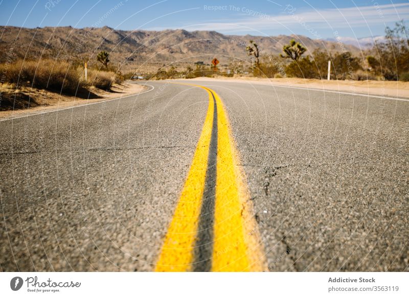 Empty highway on rocky countryside road road trip route desert asphalt sand dry heat mountain picturesque nature valley calm range freedom usa sky california