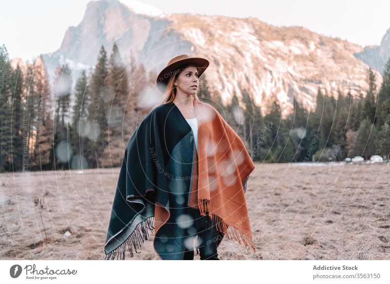 Young woman in poncho standing on mountain valley forest travel rock landscape national yosemite park hill sand female calm style cliff hat scenery woods serene