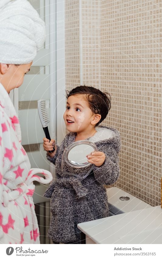 Little boy brushing hair in bathroom comb mother child adorable wet hair mirror kid childhood parenthood mom son motherhood bright together relationship toddler