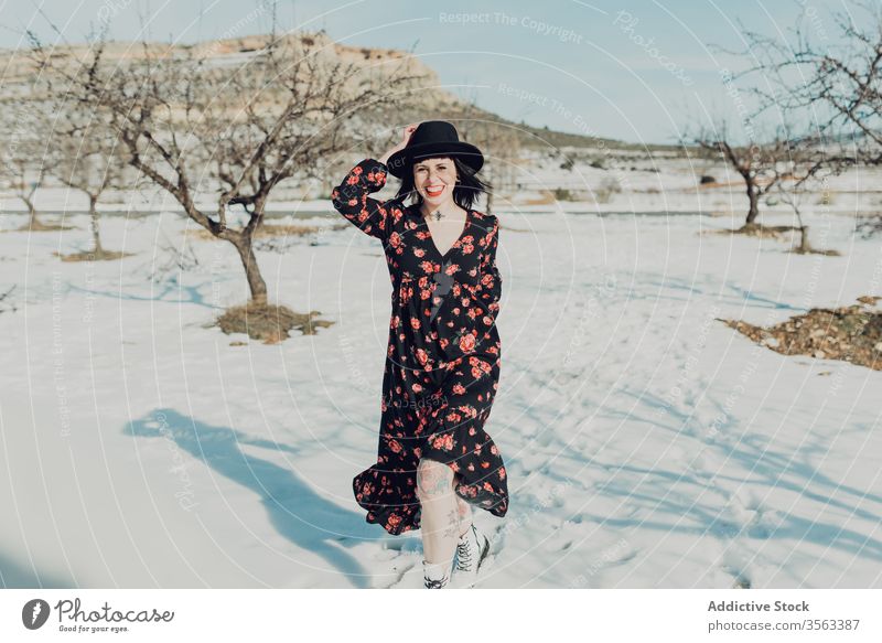 Confident trendy woman standing in snowy field style confident nature attractive looking at camera modern fashion charming colorful defiant red young sensual