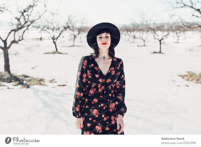 Confident trendy woman standing in snowy field style confident nature attractive modern fashion female charming serious colorful defiant red young sensual