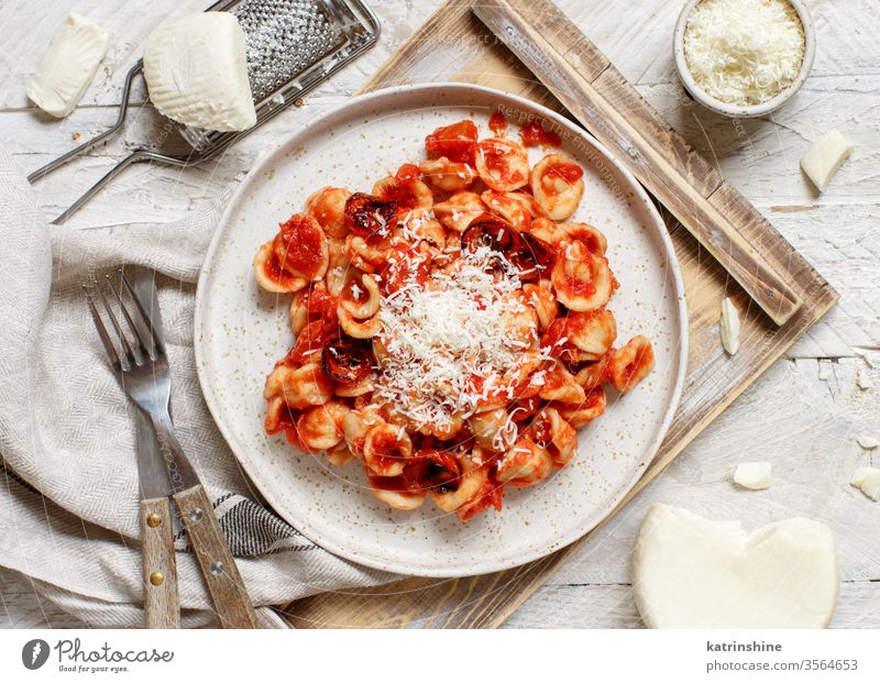 South italian  pasta orecchiette with tomato sauce and cacioricotta cheese apulia tomatoes sugo top view tray white grater wooden cooked cuisine diet dinner