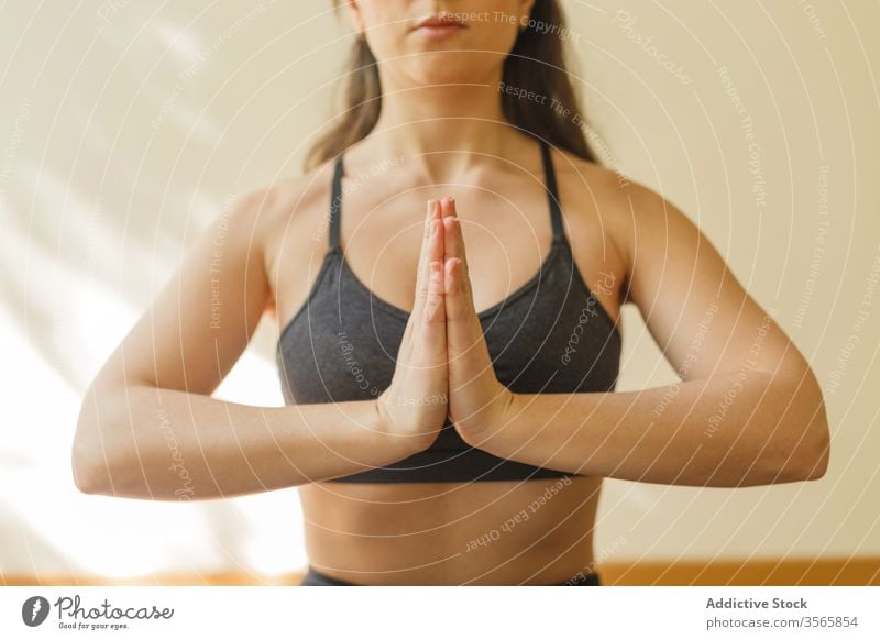 Group of three slim women sitting in lotus position on yoga mats and  meditating with their hands on knees. Focus on yoga teacher in foreground  and her Stock Photo - Alamy