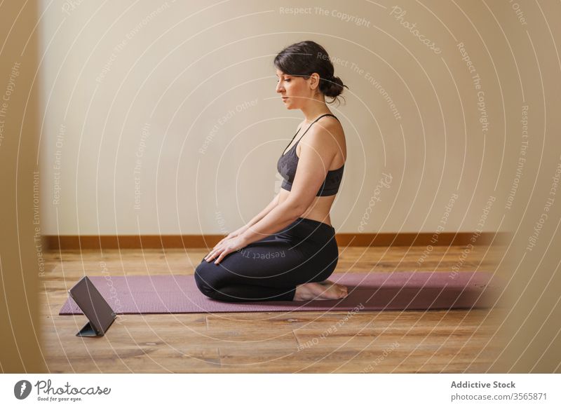 Young woman doing online yoga at home. Online fitness, home