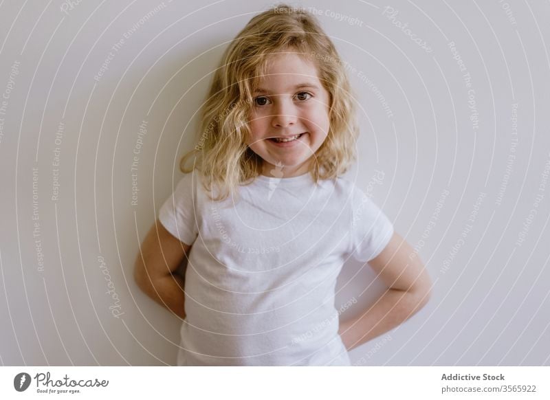 Cheerful cute girl smiling in studio cheerful smile child positive casual face expression happy kid childhood stand lean wall glad style modern contemporary