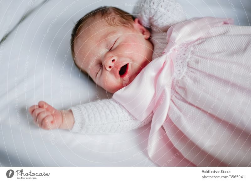 Newborn girl yawning in crib newborn baby cot adorable lying sleep cute cozy dress infant innocent child rest nap relax babyhood tranquil serene peaceful calm