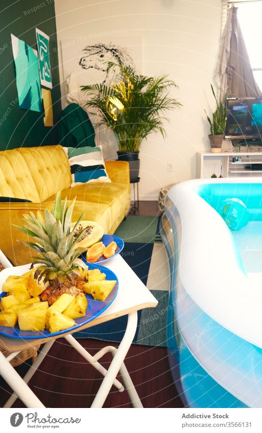 Interior of living room with inflatable pool party tropical stay at home self isolation fruit interior social distancing apartment having fun fresh creative