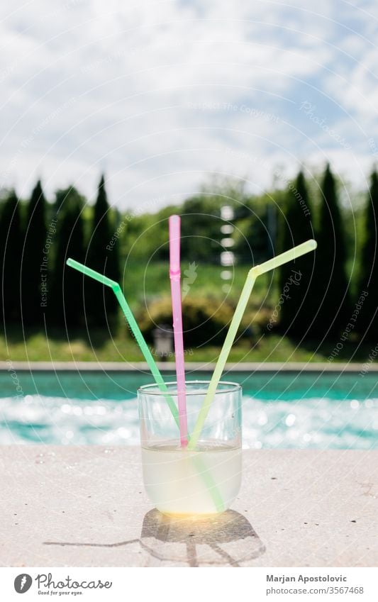 Glass of lemonade with three straws by the swimming pool alcoholic aqua beverage blue cocktail cold colorful colors cool copy drink enjoy exotic fresh freshness