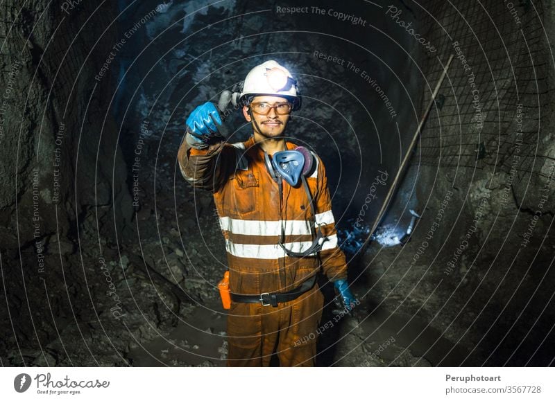Miner in the mine. Well-uniformed miner inside mine raising thumb cave industrial underground shaft one outdoor outfit overalls person positive power production