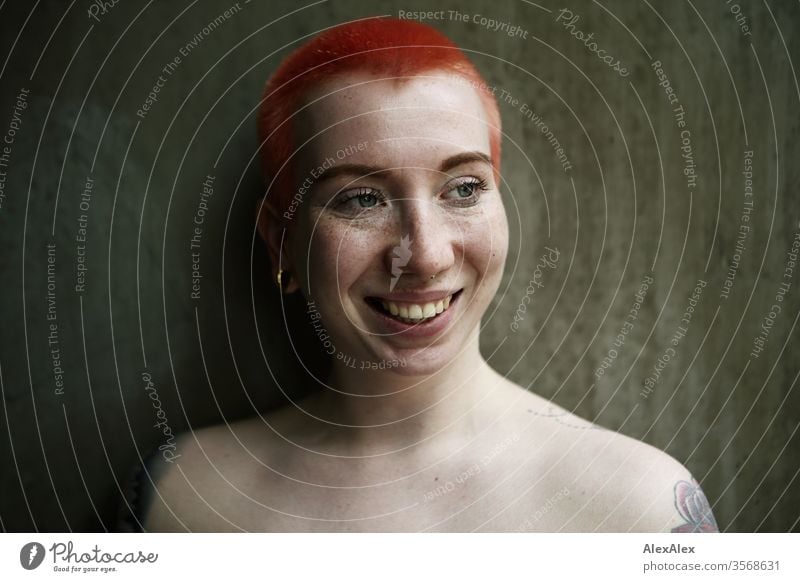 Portrait of a laughing young woman in front of a concrete wall Woman 18-25 years already Slim Freckles Concrete Wall (building) Red-haired Jewellery Piercing