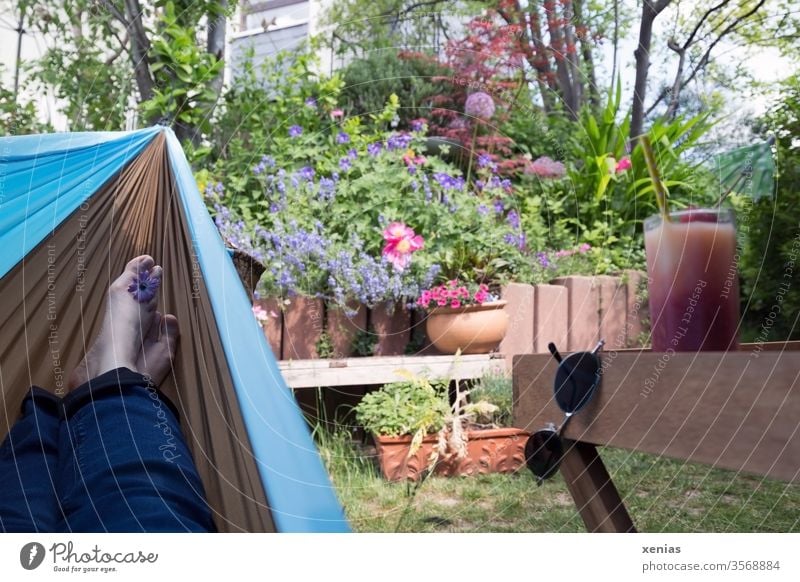 Feet in a hammock overlooking the garden and drink provided - deep relaxation guaranteed Hammock feet Garden Relaxation Sunglasses Beverage Juice Glass Blossom