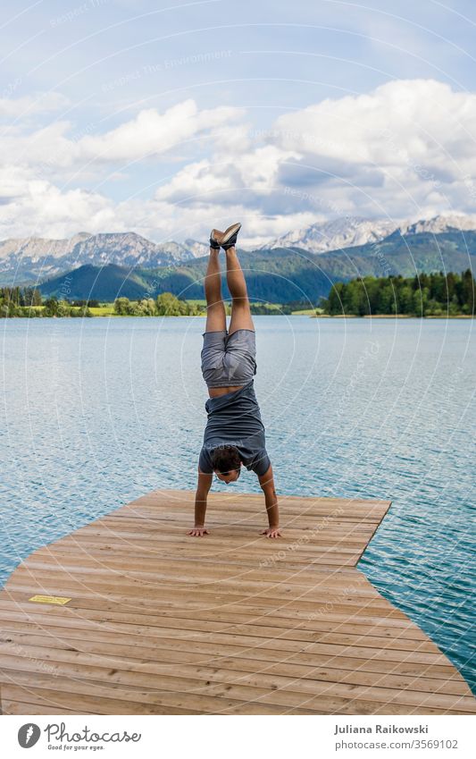 Man doing handstand in front of a beautiful mountain panorama in Bavaria Rock Weather Picturesque Hiking Vacation & Travel Vantage point Exterior shot