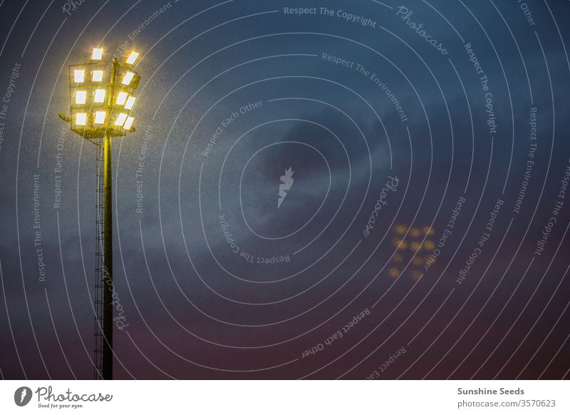 Bright sports stadium lights on a cloudy evening activity afternoon background black blue bond market bright caution clouds danger dark dark times economy