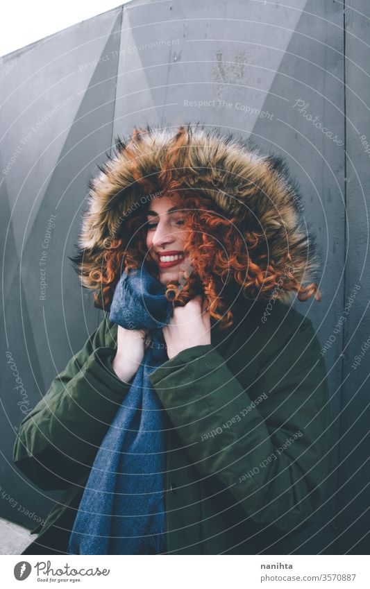 Beautiful portrait of an attractive redhead woman wearing winter clothes pretty face youth lifestyle curly hair ginger scarf warm model fashion trendy freckles
