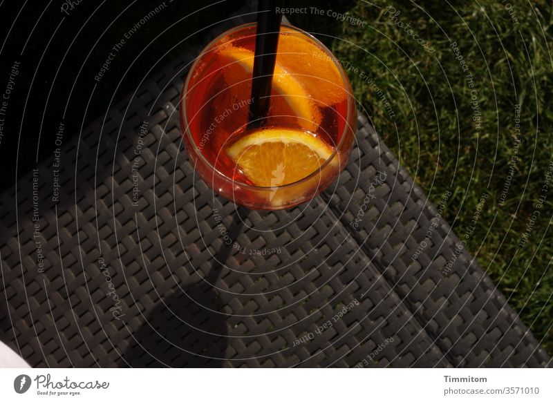 The drink waits in the evening sun Glass straw Alcoholic drinks celebration Drinking Orange slice Beverage Cocktail Light Evening Black conceit