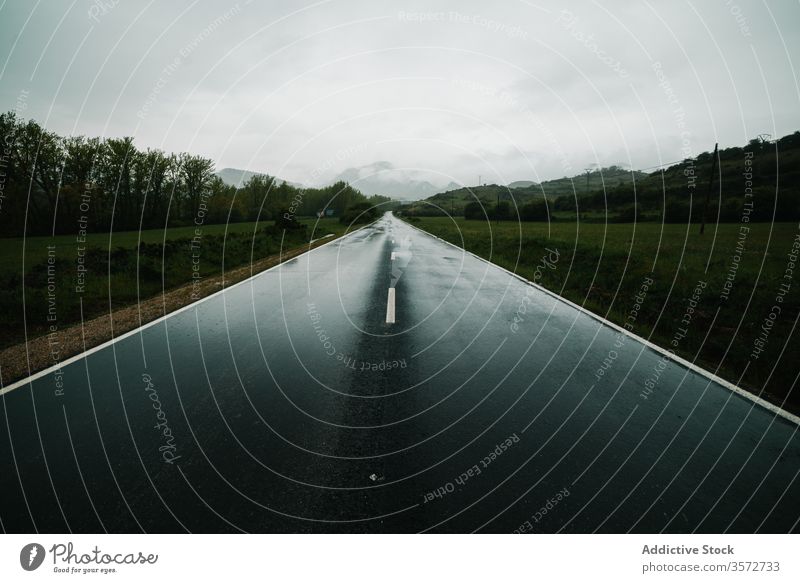 Countryside road among mountainous terrain with green forest countryside field windshield summer nature drive car valley speed direction highland trip landscape