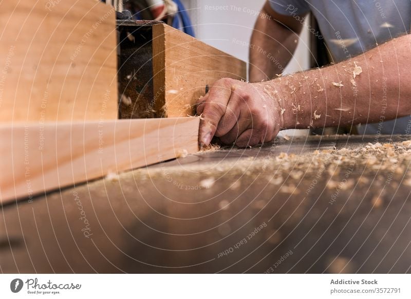 Craftsman milling lumber using machine in carpentry workroom sawdust hand timber craftsman woodwork joiner precise master design carpenter male workshop
