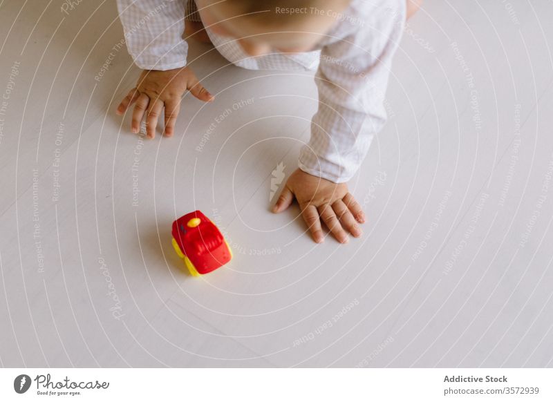Cute little child playing with toy car crawl toddler weekend entertain having fun kid childhood cute adorable wooden floor joy playful game innocent carefree