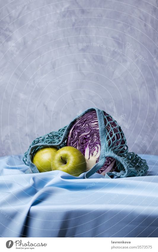 Organic green apples  and red cabbage in zero waste bags, selective focus diet drapery food fresh fruit groceries harvest healthy blue linen mesh organic raw