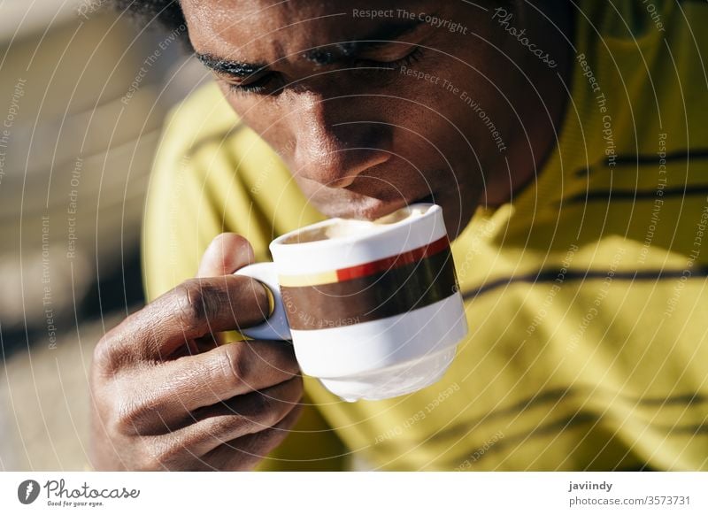 Black man enjoying coffee in cafe while sitting at the table outdoors adult african afro american attractive background beautiful beverage black casual cheerful