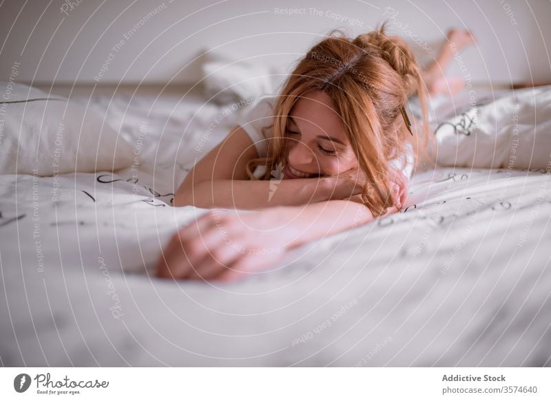 Delighted young sexy lady lying on bed and smiling · Free Stock Photo