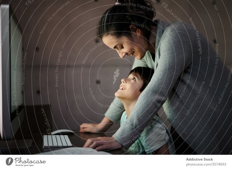 Mother helping kid with homework during online studies mother study education computer explain together child mom schooling son learn knowledge device gadget
