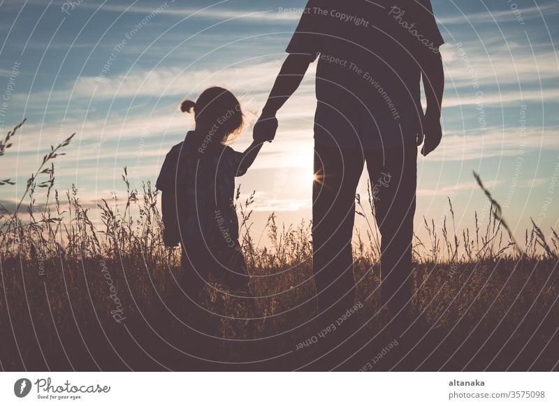 Father and sad son standing in the park at the sunset time. father boy family parent care man people dad child young kid depressed grief unhappy adult together