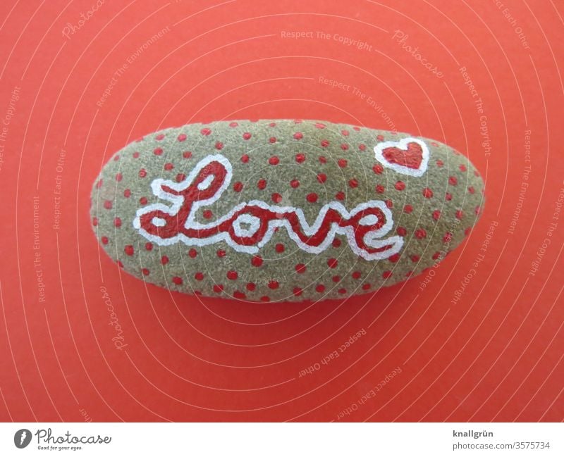Red dotted lucky stone with the writing "Love" on a red background Lucky Stone Creativity Romance Graffiti Heart Infatuation Emotions Sign Characters