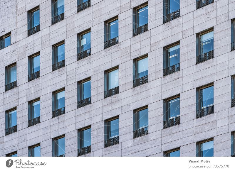 Rows of windows of a business building built in roman travertine marble facade architecture architectural architectonic urban color structure abstract outdoors