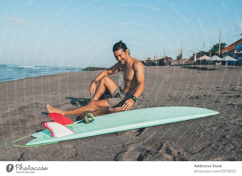 Male surfer with dog resting on beach man together pet sand sit friend surfboard companion young shirtless male summer relax coast shore lifestyle vacation