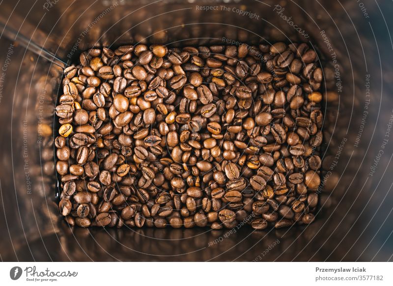 Roasted brown coffee beans inside square tin can as a background. roasted texture white black espresso dark drink natural light isolated color seed food closeup