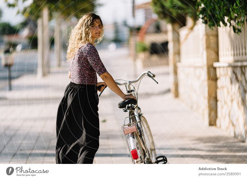 Tranquil woman with bicycle in park bike summer weekend enjoy walk cyclist calm female sunny tranquil serene outfit daytime rest green tree lady carefree