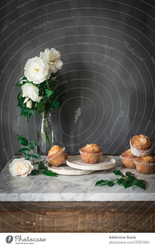 Delicious cupcakes in composition with bouquet of fragrant white flowers in vase on table food treat rose meal dessert pastry leaf fresh nutrition bloom