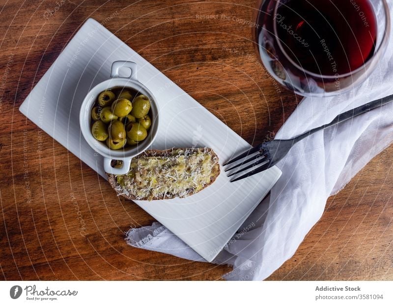 Olives and wine on wooden table olive snack kitchen bruschetta wineglass toast red wine bowl pickled sandwich plate meal food appetizer delicious gourmet drink