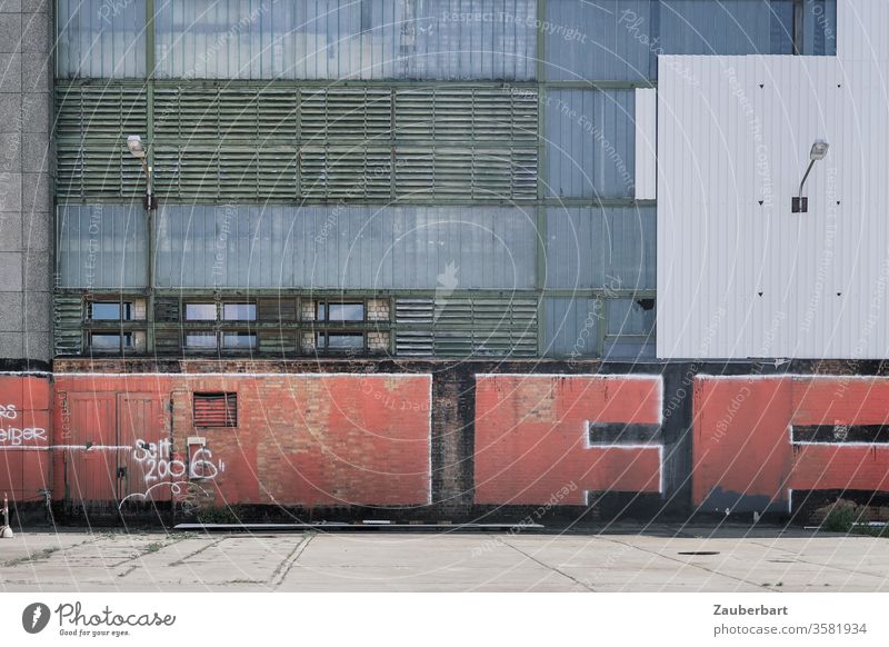 Facade of a factory made of metal with a rectangular pattern and red graffiti on it, in Oberschöneweide Metal Rectangles slats Gray White Lantern Red urban Town