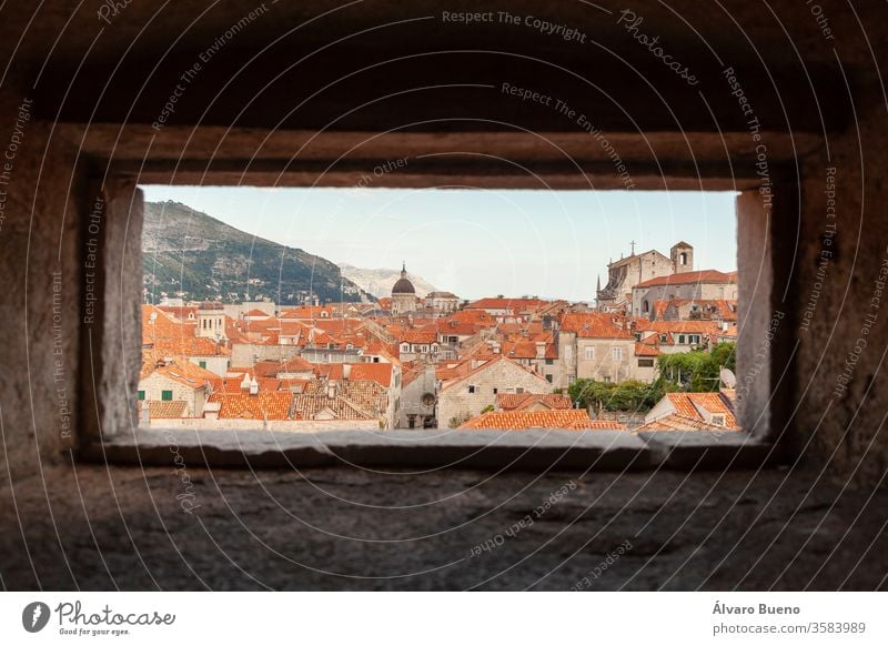 Orange roofs of Dubrovnik, seen from the wall, through a small window, under the shadows of afternoon clouds, on the banks of the Adriatic Sea. adriatic sea
