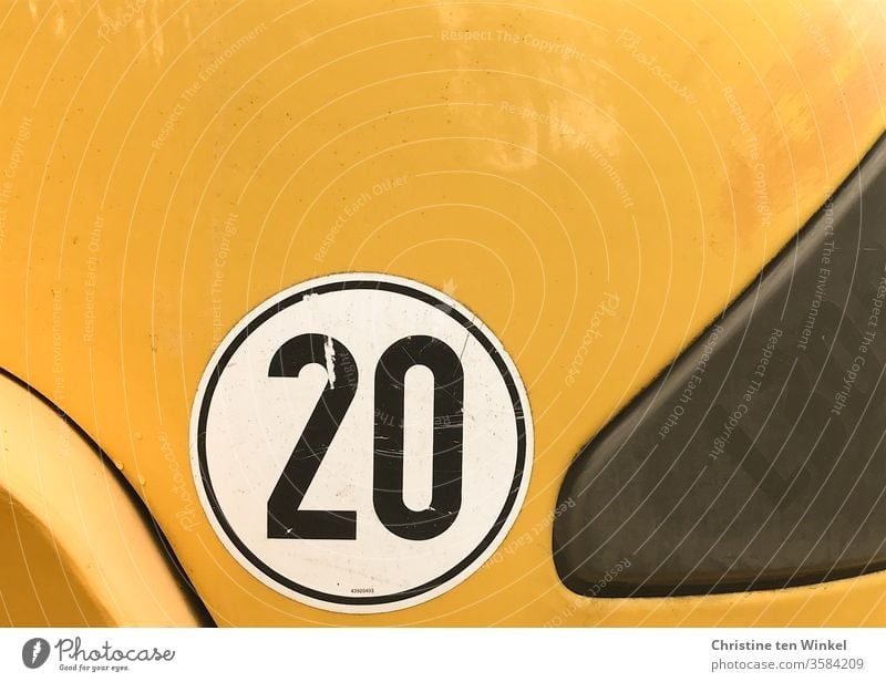 black 20 on white and yellow twenty Label Digits and numbers digit Black White Yellow yellow background Utility vehicle Sign Vehicle Signs and labeling