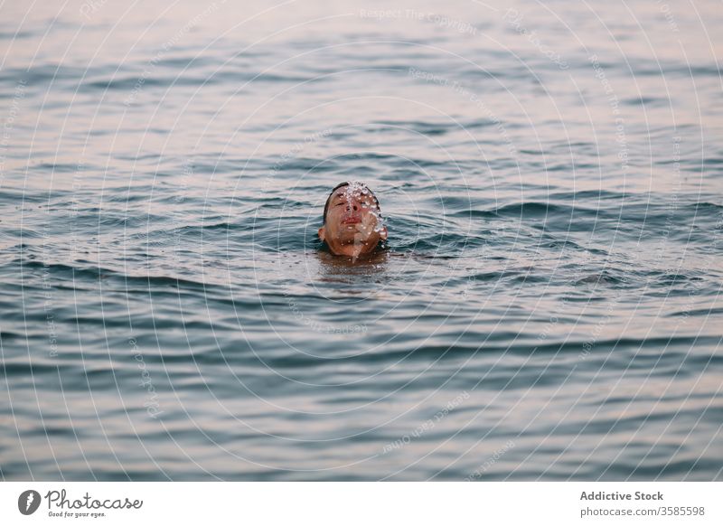 Young man swimming in clean sea water swimmer healthy active leisure vacation ocean dive male young satisfied spit out deep calm blue transparent sunny daytime