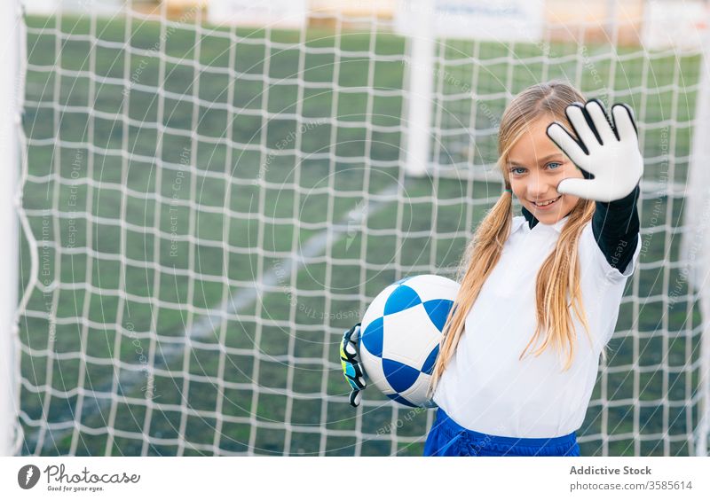 Happy young female player with ball in football arena at sports stadium girl soccer field uniform happy child kid club childhood athlete equipment smile preteen