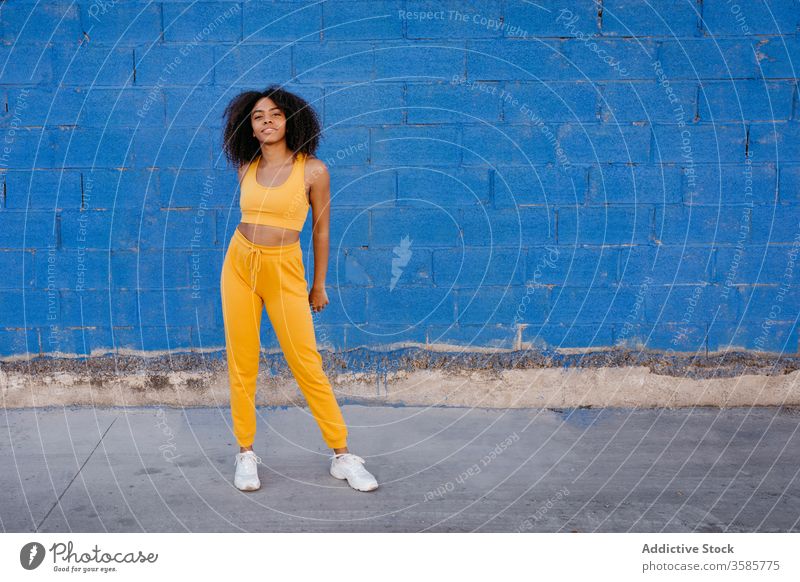 Cheerful African American woman with afro hairstyle in a carefree pose move vivid vibrant cheerful smile motion color female black ethnic african american