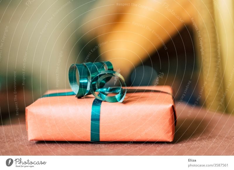 A gift with a gift ribbon for Christmas or a birthday in front of a blurred background. Gift Donate Birthday Mother's Day Gift wrapping Packaged