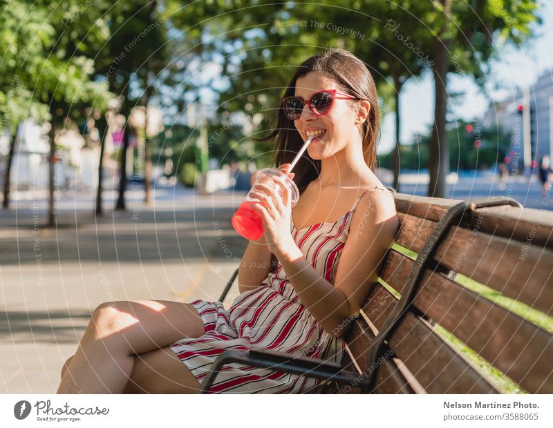 Cute woman in the street. She is drinking a cold tea in the summer. She is wearing sunglasses. outdoor girl people young wellness active blue adult female women