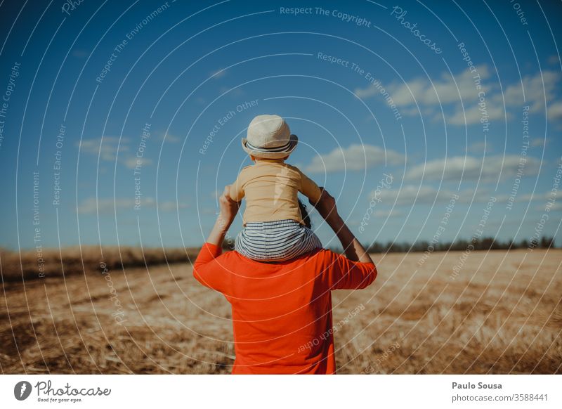 Rearview Mother with Son on shoulders motherhood Baby Shoulder Rear view Red Field fields Walking Caucasian Lifestyle Family & Relations Child Happiness Cute