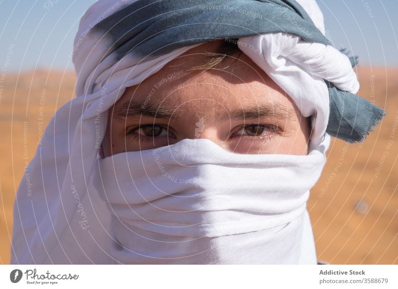 Traveling man in protective headscarf in desert travel sand vacation tourism holiday traveler male morocco africa summer nature adventure headgear headdress