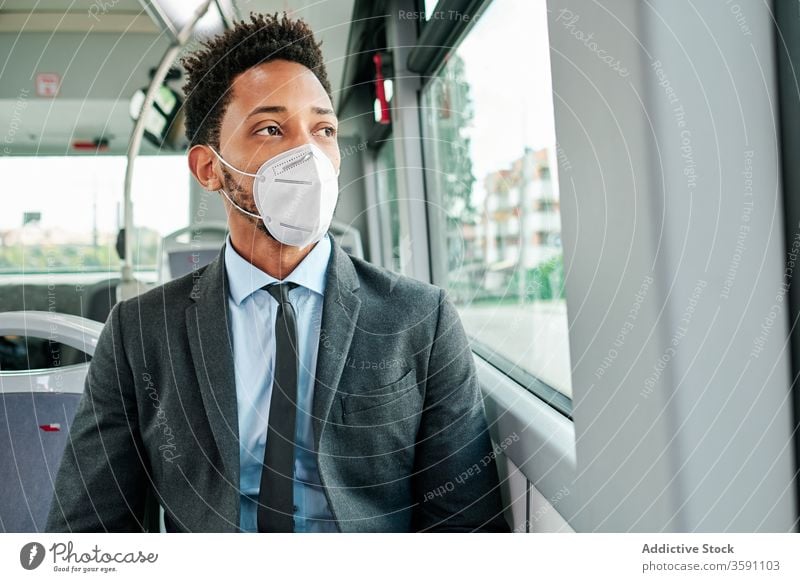 Serious male entrepreneur wearing respirator in bus man public transport mask protect coronavirus outbreak passenger ethnic black african american seat suit