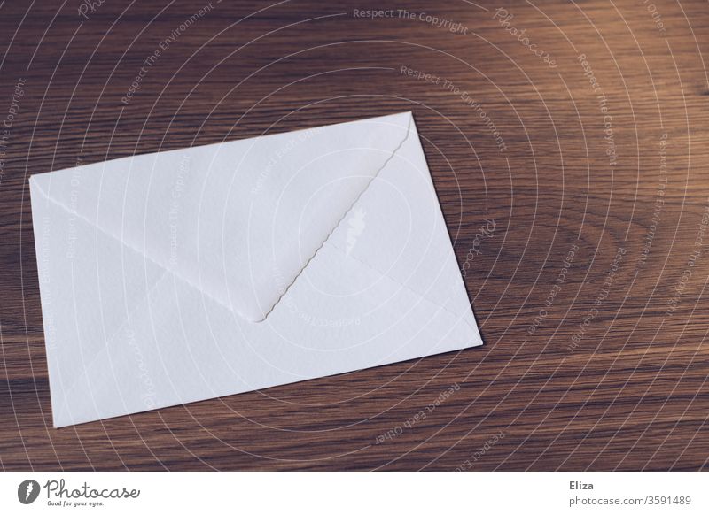 White envelope on a wooden table. Writing letters. Mail. Envelope (Mail) Letter (Mail) Communicate Paper Transmit Wood Table Wooden table Write Brown Mailing