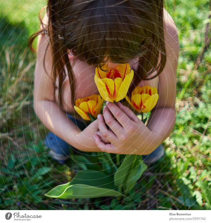 Girl dresses tulips green experiential education experience Experience Nature Garden enjoying To enjoy judge Colour photo luck Joy Infancy Exterior shot