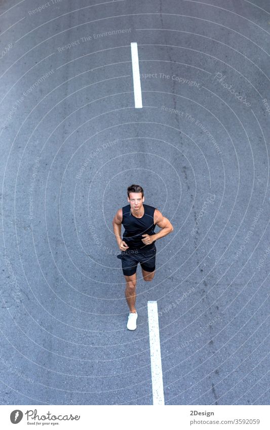 Top view athlete runner training at road in black sportswear. man adult jogging lifestyle athletic sporty exercise young active healthy summer activewear fit