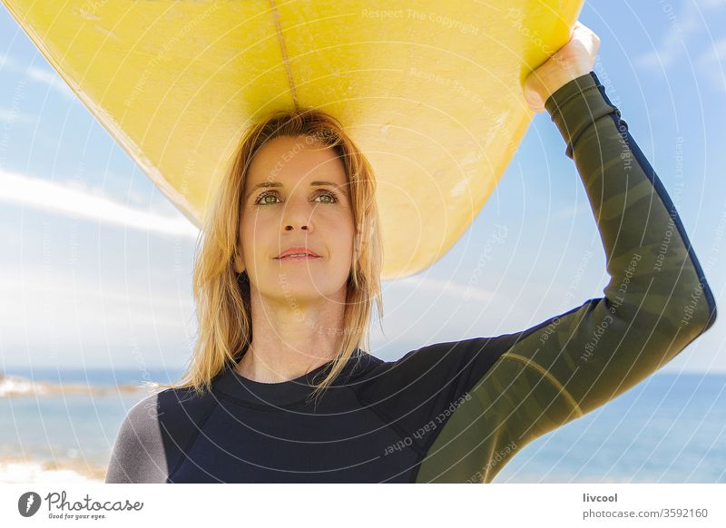 surf woman with yellow board on her arms on the french coast surfer blonde lifestyle people one person human sport adult portrait outdoors scene sky sea