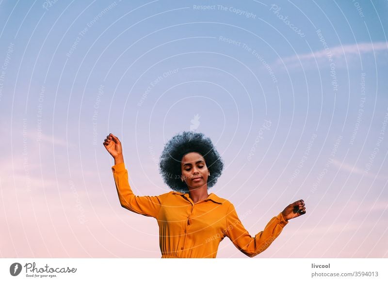 black woman dancing with the wind outdoors blue sky girl young people portrait lifestyle cool lovely garden yellow flower exterior nature afro hair